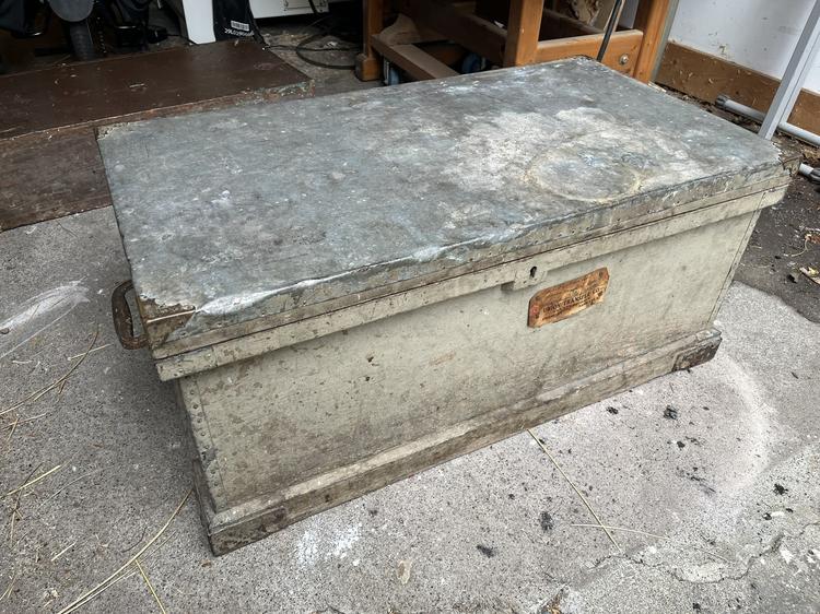 The large tool chest, painted grey, with a tin-covered lid