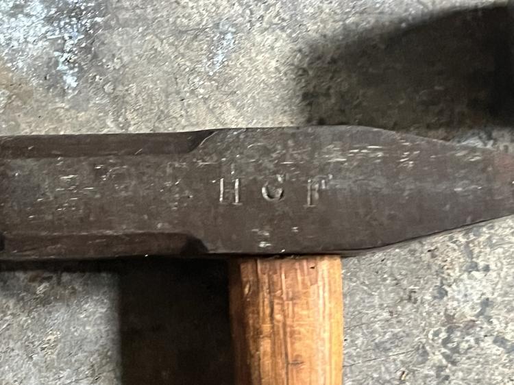 The letters H C F struck into the side of a hammer head