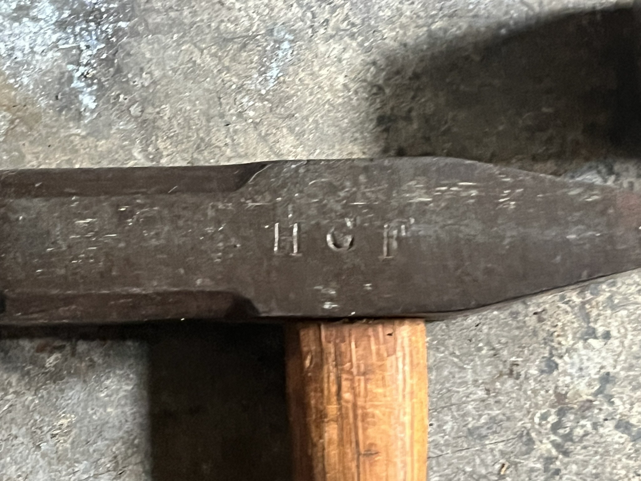 The letters H C F struck into the side of a hammer head