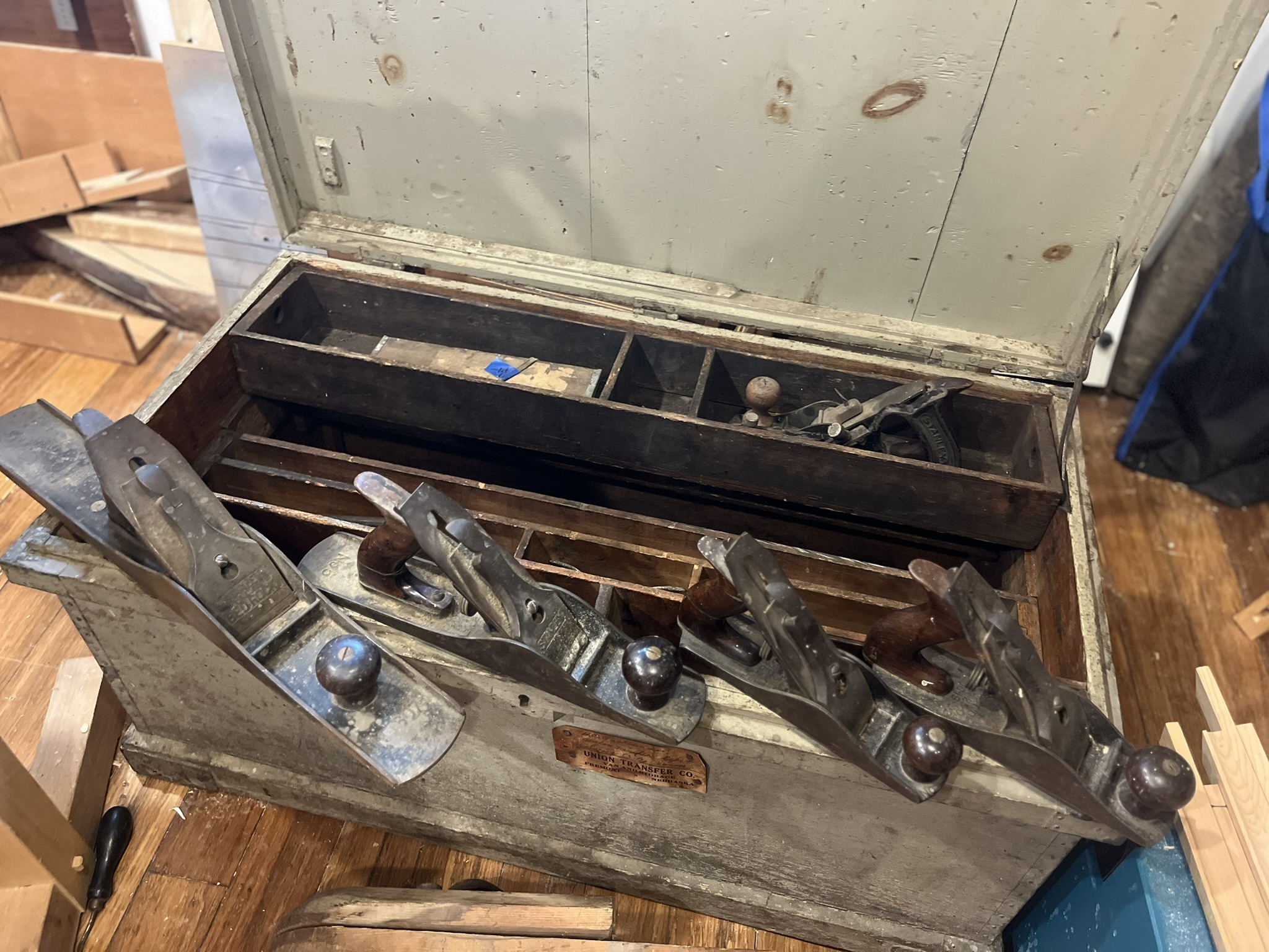 Five bench planes standing in the open chest, their rosewood knobs and totes still intact