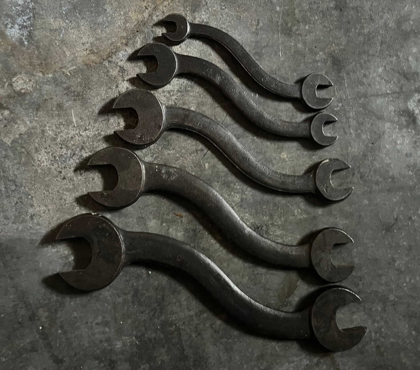 Five S-shaped open-end wrenches arranged by size